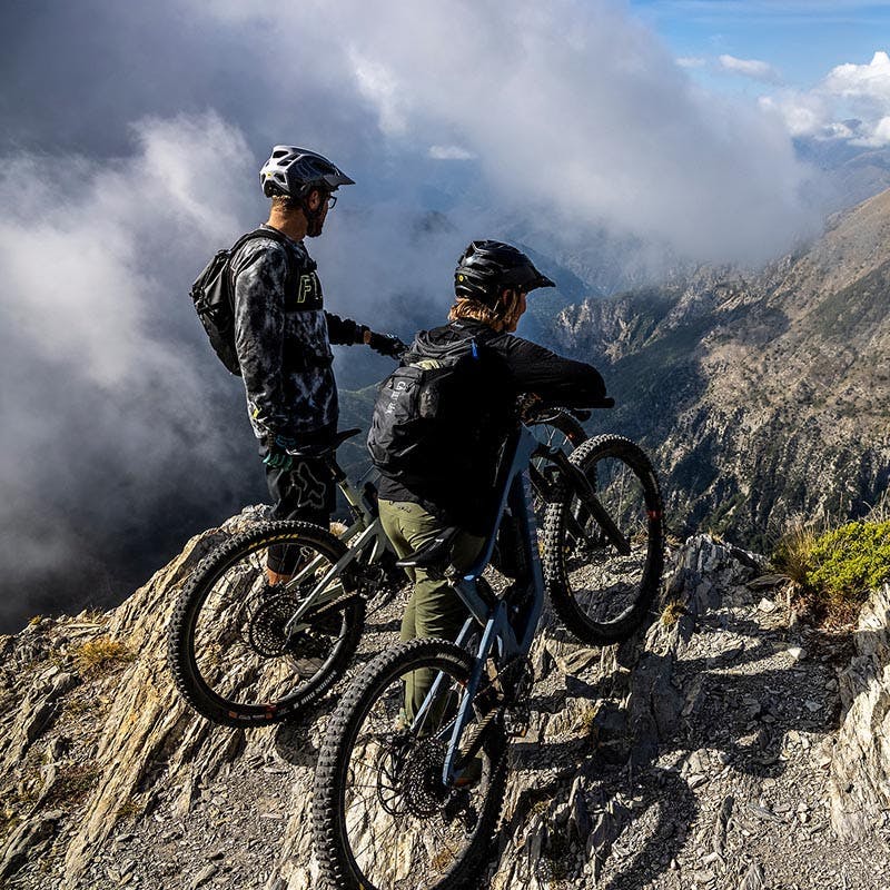2 mountain bikers looking out over a ridge