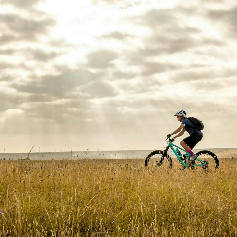 Mountain Biker riding a Santa Cruz Bicycle through a field in Colorado
