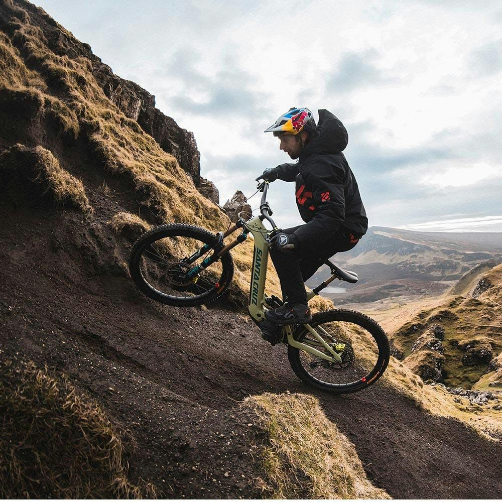 Danny MacAskill riding his Heckler uphill on a singletrack trail