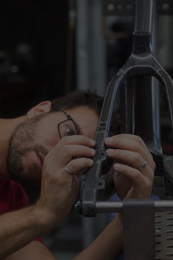 An engineer inspecting the rear triangle on a hardtail mountain bike frame