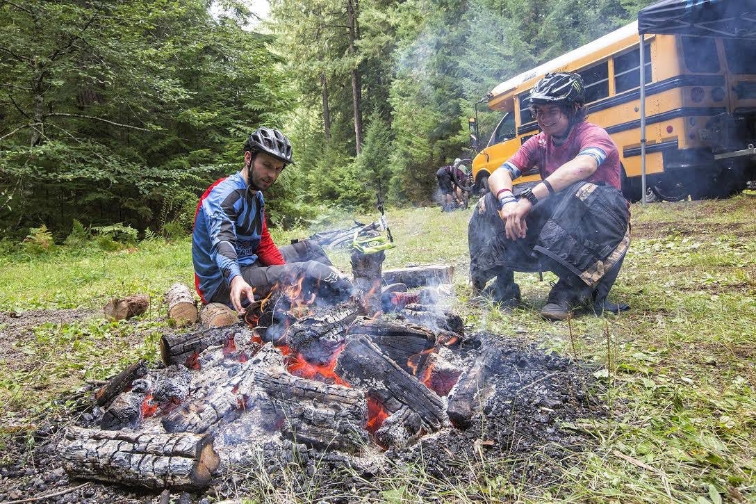 2 mountain bikers sitting by the fire