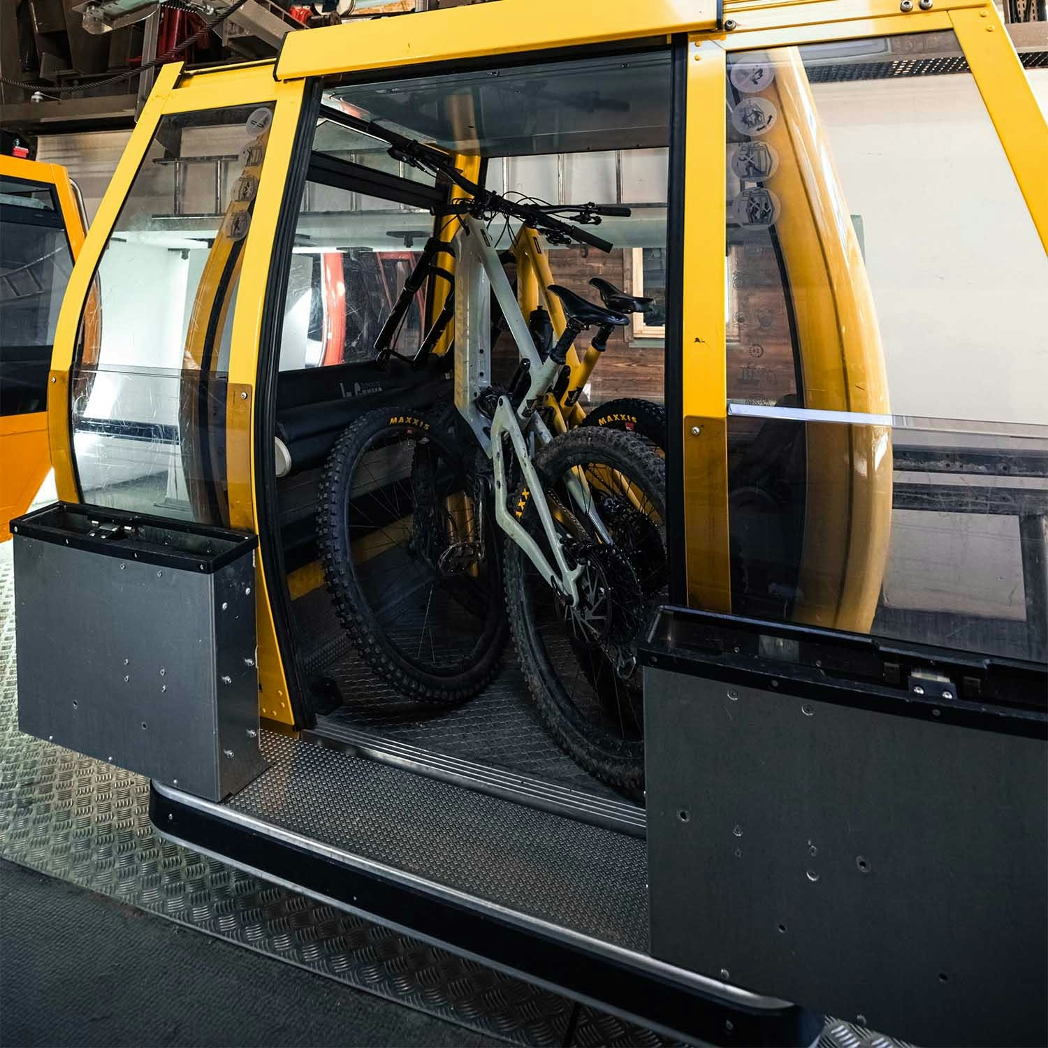 A yellow gondola cab with 2 Santa Cruz Mountain bikes