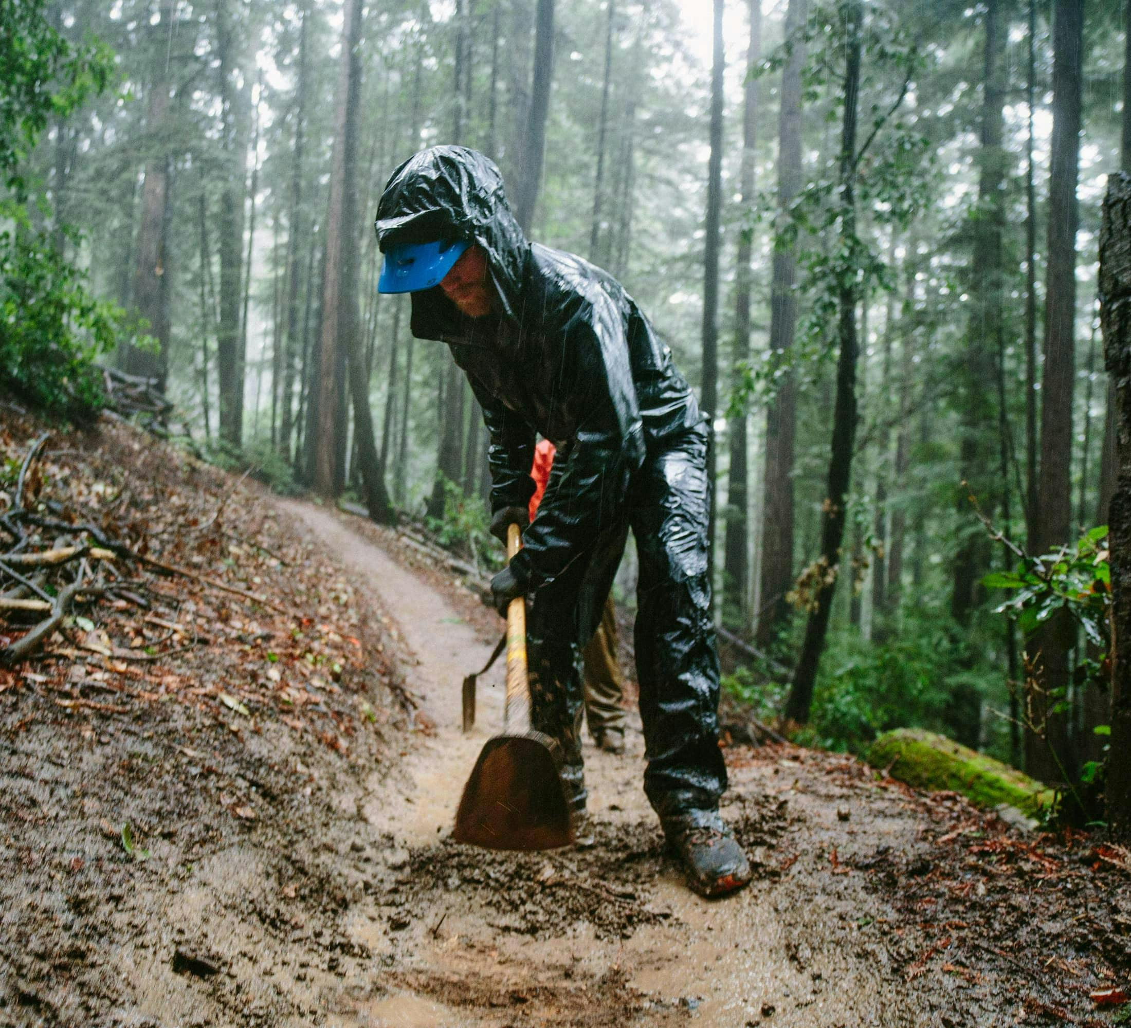 Trail maintenance with Land Trust of Santa Cruz County in California - Trail worker digging up a portion of the trail