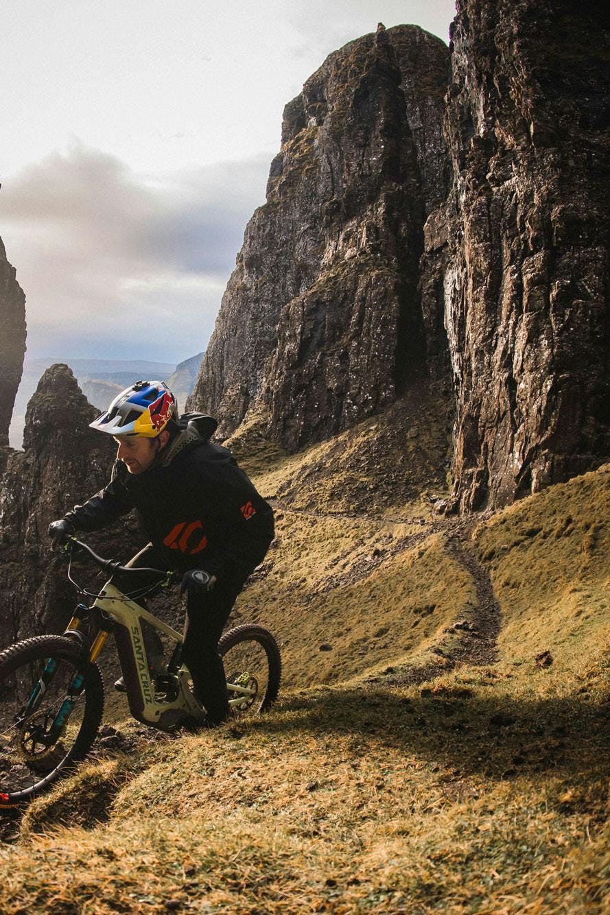 Danny MacAskill riding his Heckler 9 emtb up a rocky singletrack trail