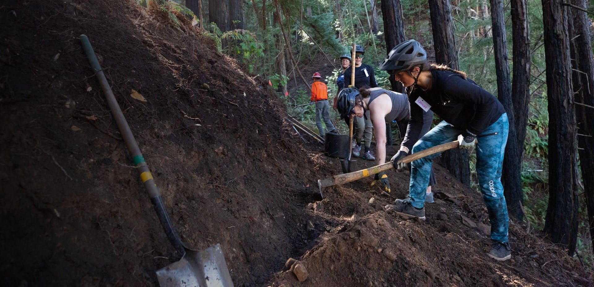 Hannah Mirsepassi and other mountain bikers building a section of singletrack trail. 