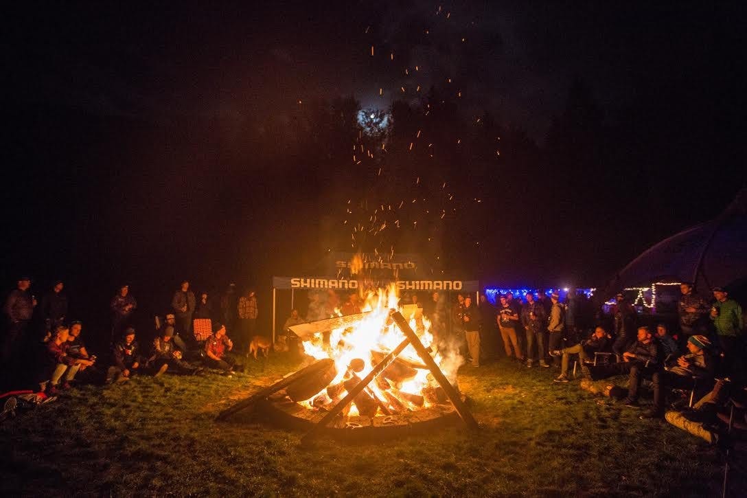 a large bonfire and the Trans Cascadia racers and staff enjoying the warmth