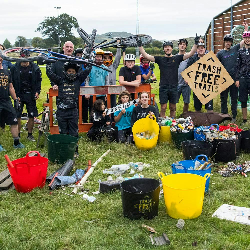 A group of cyclists showing off the trash that they have collected 