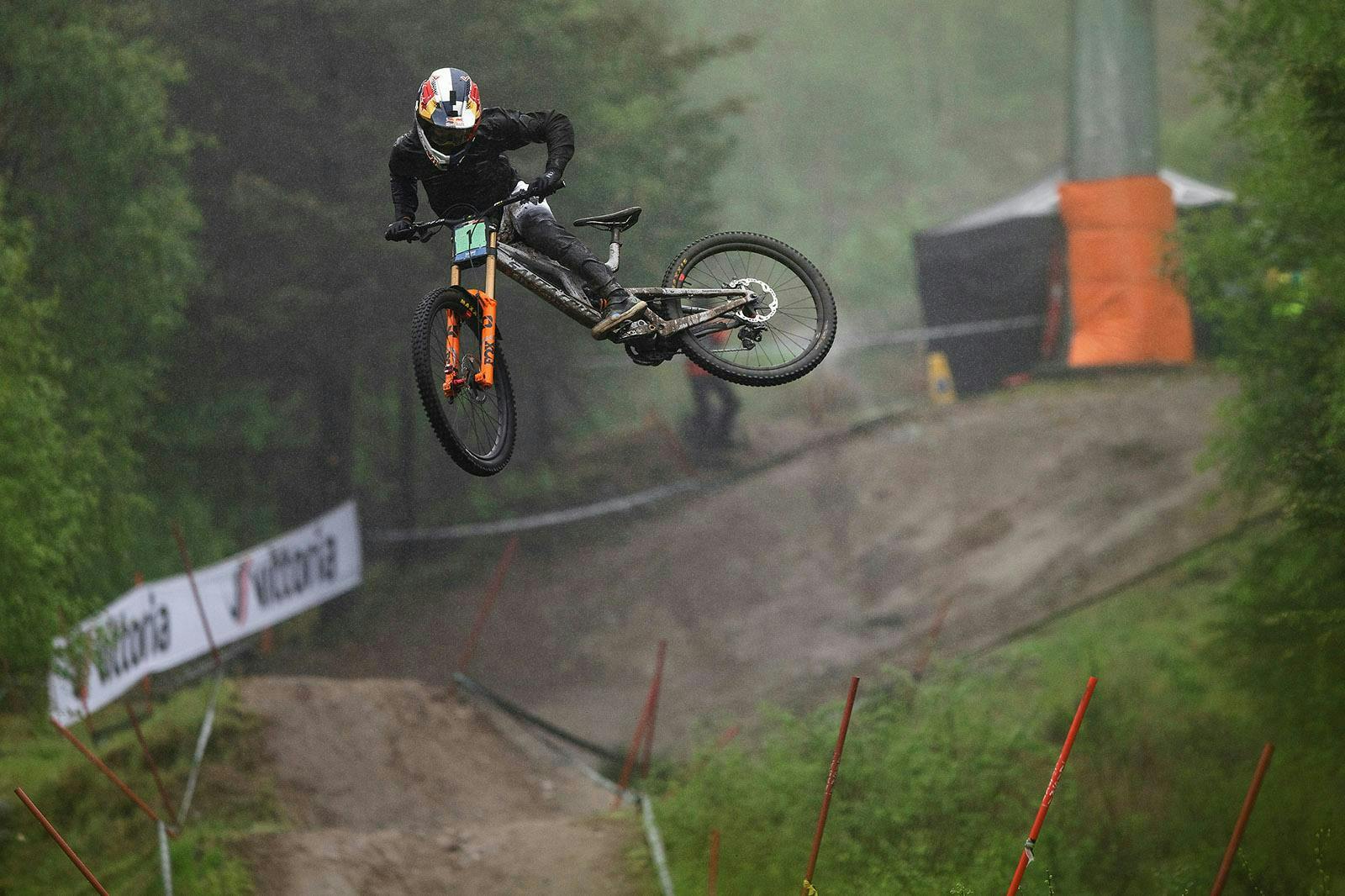 A downhill racer whipping off of a jump 
