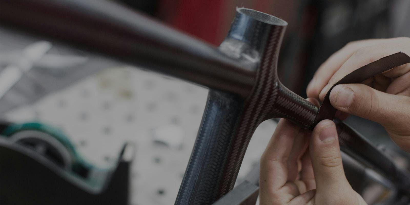 An engineer adding pieces of carbon fiber to the rear triangle of a hardtail bicycle frame