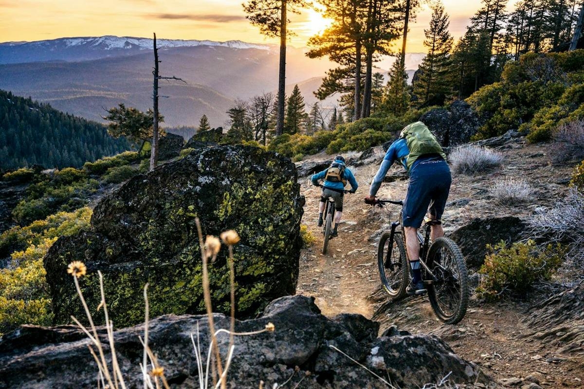 Two mountain bikers riding down a singletrack trail