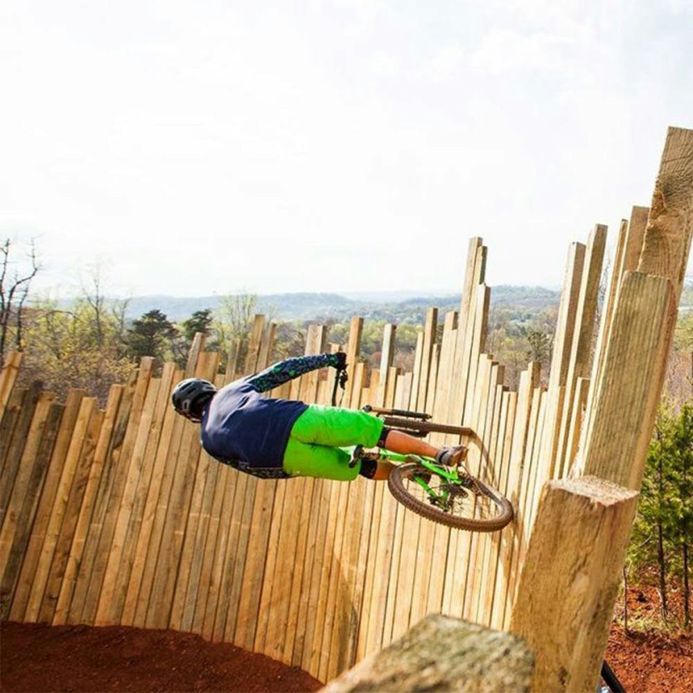 A mountain biker riding a wooden wall ride