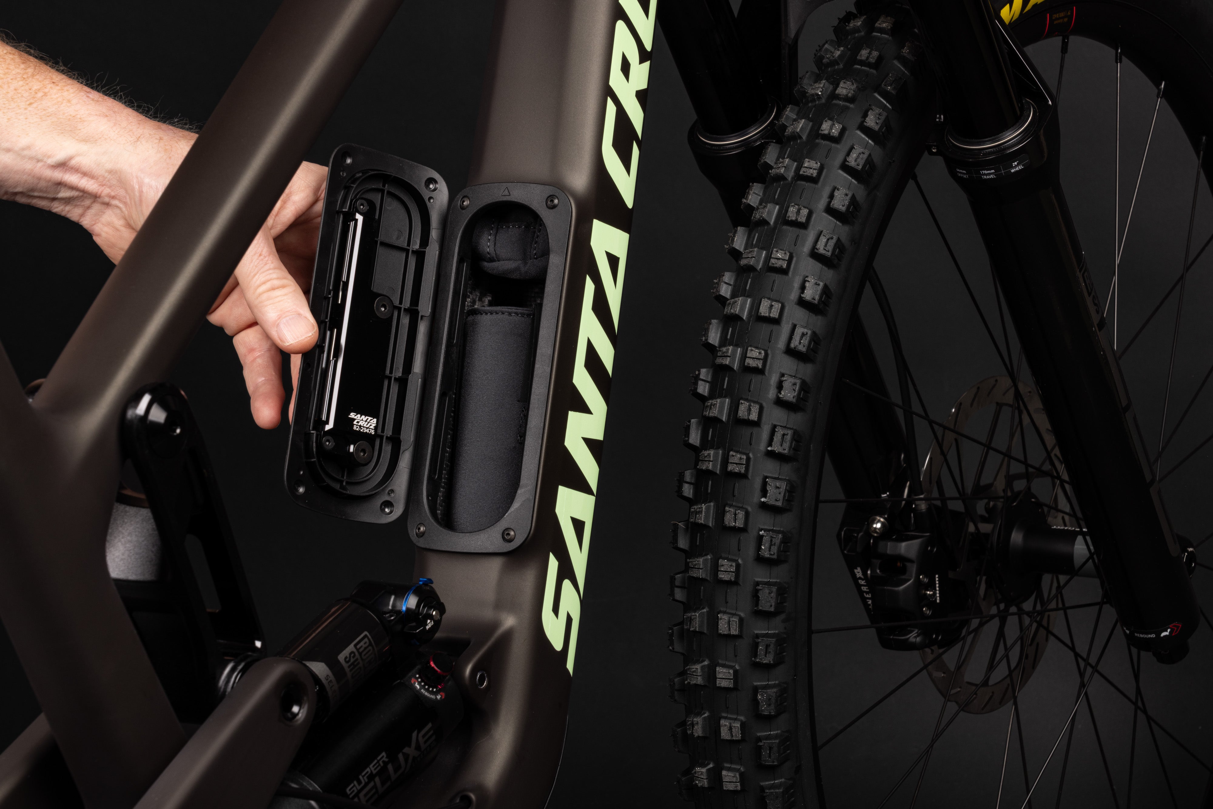 Close-up of a Santa Cruz mountain bike with a hand interacting with a component.