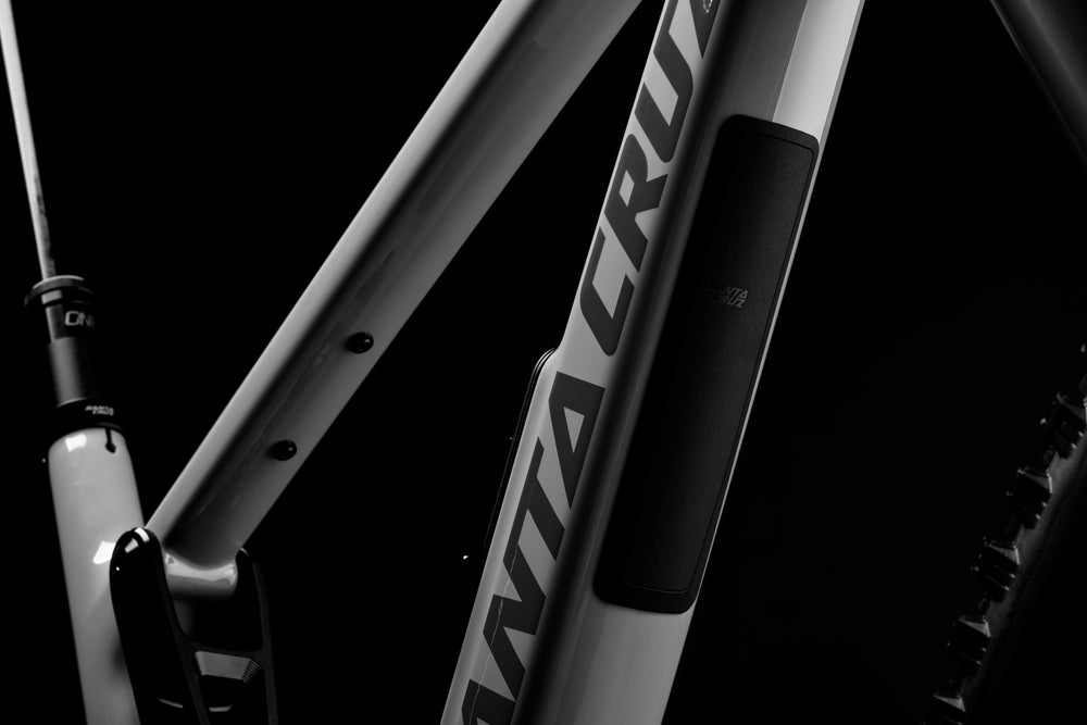 Close-up of a bicycle frame with 'Santa Cruz' branding on a black background