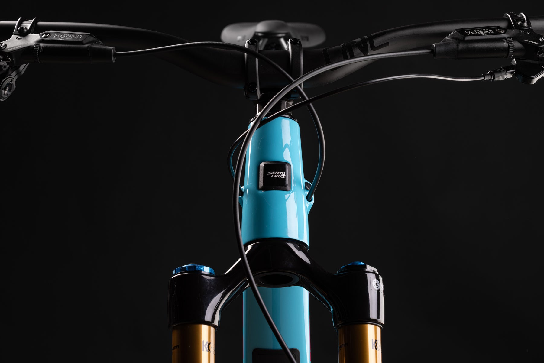 Close-up of a bicycle with a blue frame and black components on a dark background