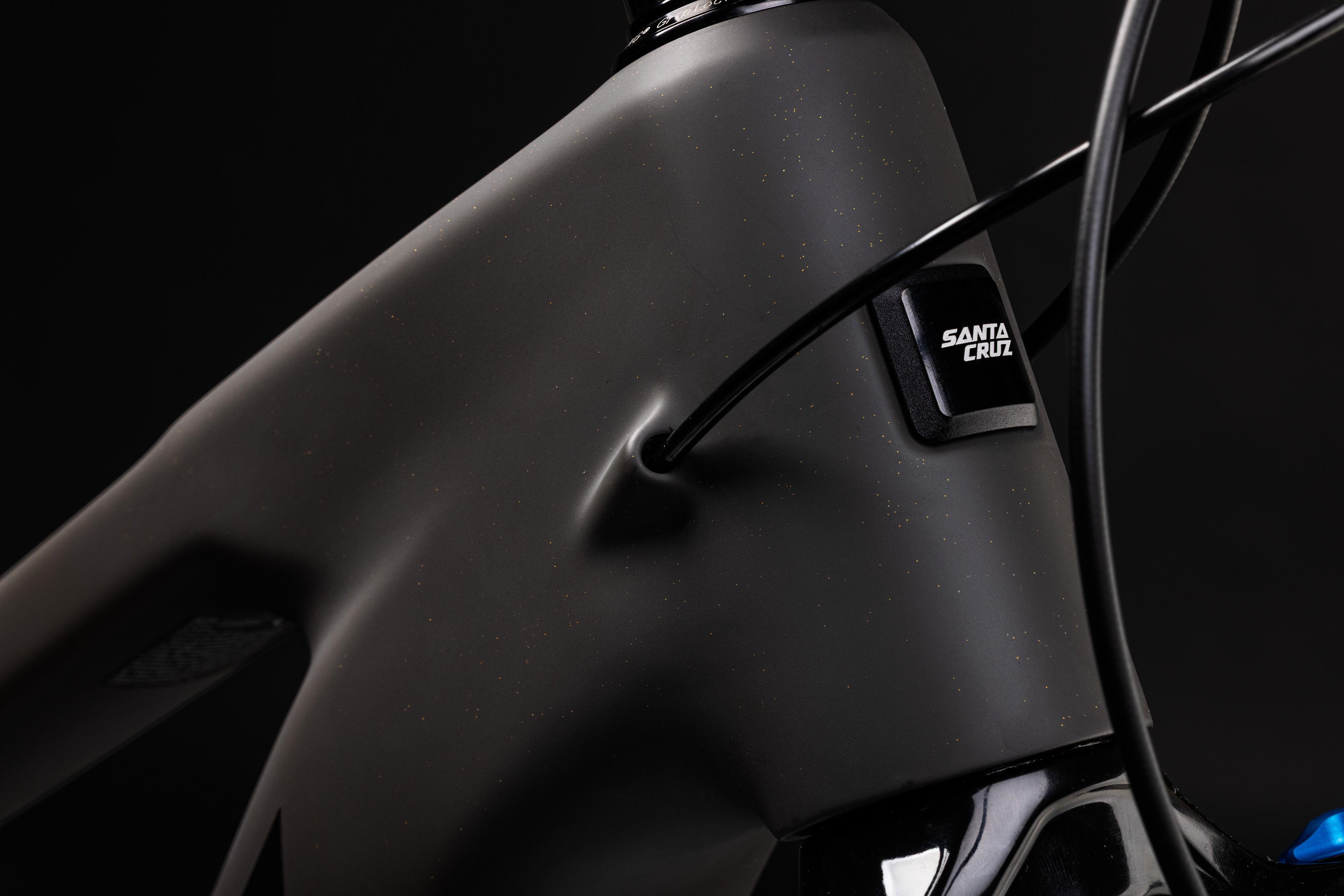 Close-up of a bicycle frame with 'Santa Cruz' branding on a black background